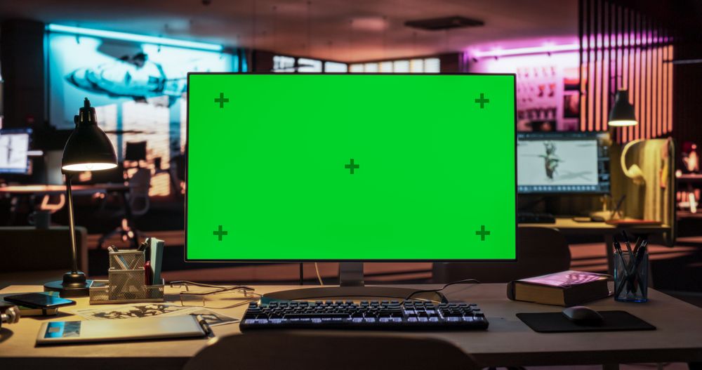 Desktop Computer with Mock Up Green Screen Chroma Key Display Standing on the Desk in the Empty Creative Office Lit by Neon Lights.