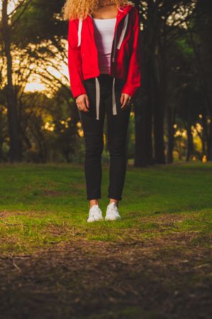 Crop sportive woman standing on meadow