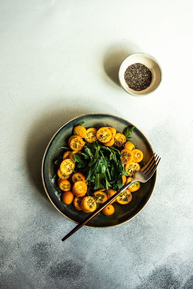 Fresh kumquat & arugula salad in bowl