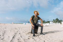 man sitting on the carrying baggage, beautiful beach, enjoying amazing view.