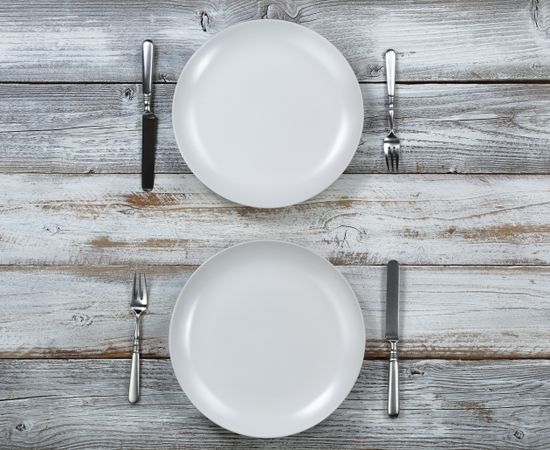 Dinner table setting on rustic wood in overhead view