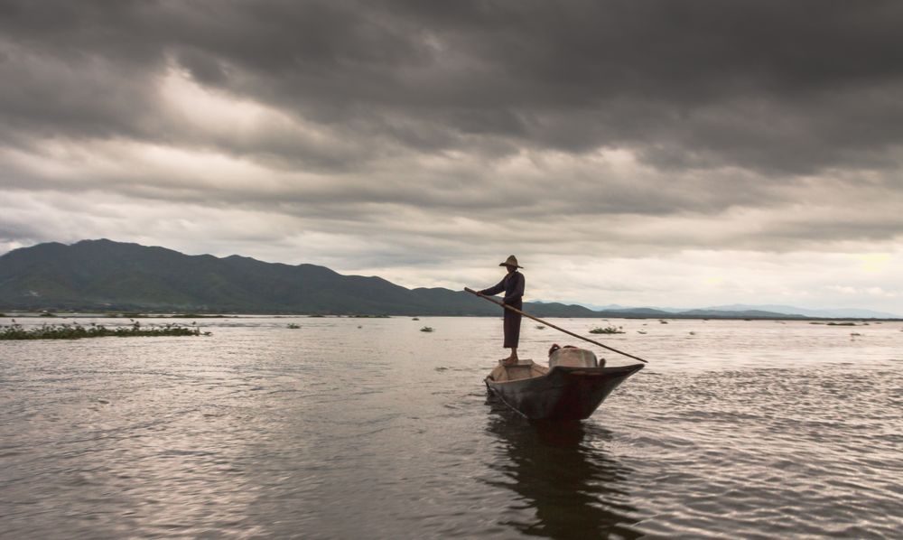 Shan, Myanmar - June, 25 2012: Anonymous fisherman standing on boat