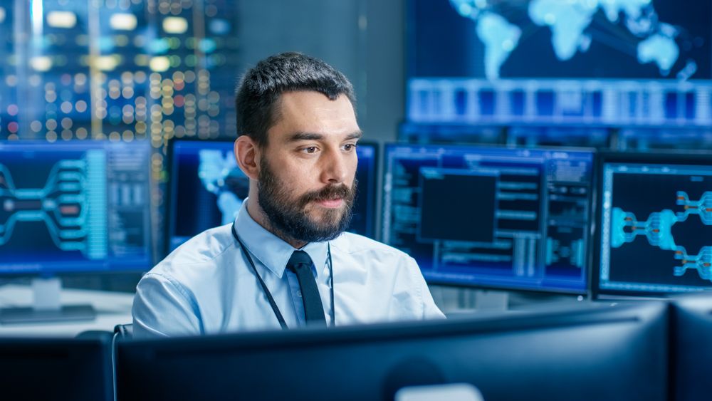 In the System Control Center Operator Working Surrounded by Displays Showing Relevant Data.