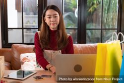 Asian woman working on her shipping business from home bGO3Yb