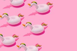 Inflatable unicorn pool toy on pastel pink background