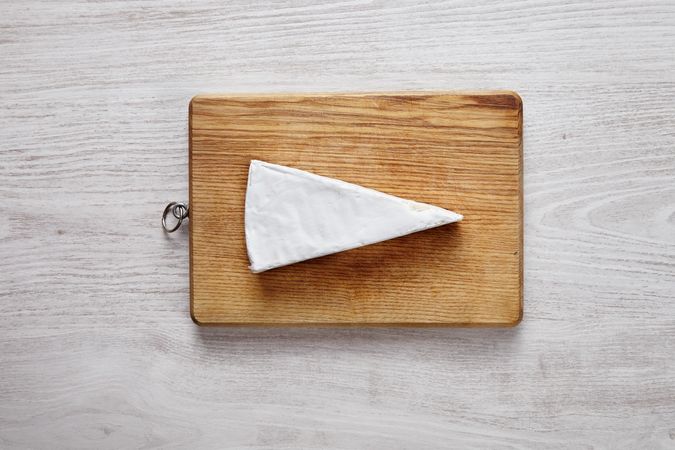 Large chunk of light cheese on wooden board