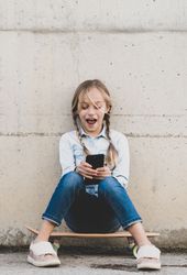 Kid using mobile phone with skate