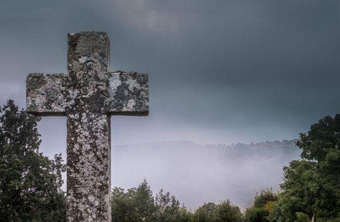 Close up of cross tombstone on overcast day