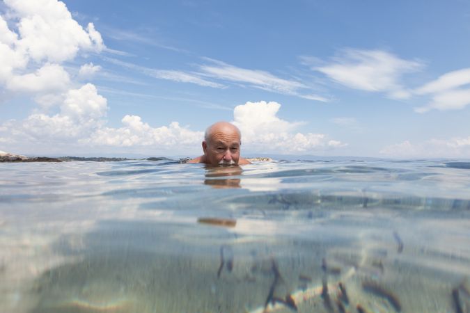 Cheerful man swimming in sea water