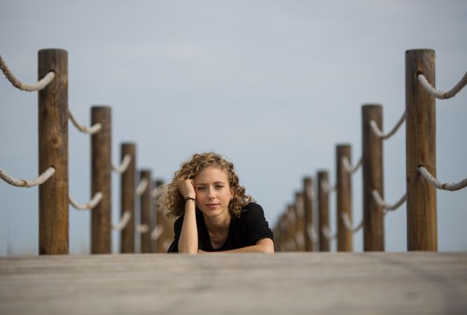 Young woman sitting on footbridge