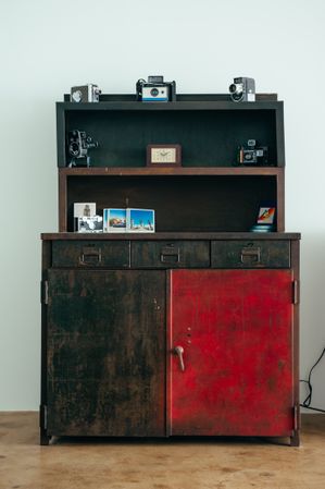 Vintage metal Army cabinet with film cameras and photo prints on shelves