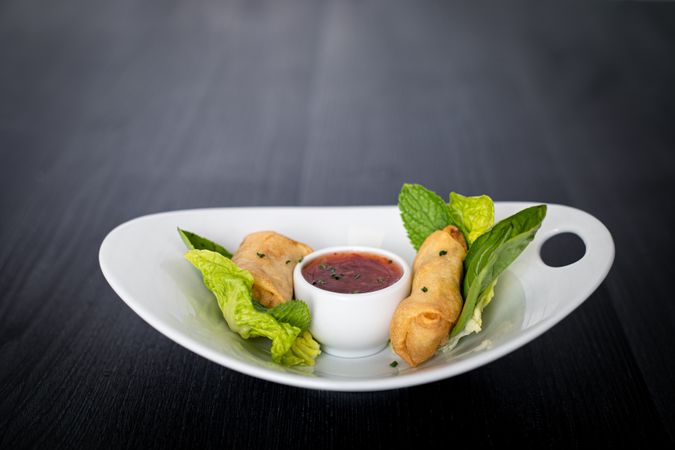 Vietnamese rolls with sweet chili on glass plate