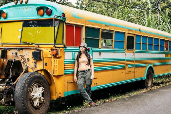 Woman leaning on a broke vintage school bus
