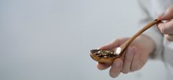 Man holding spoon with grains