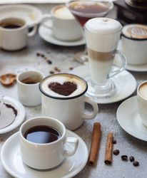 Coffee varieties with foam art on stone background