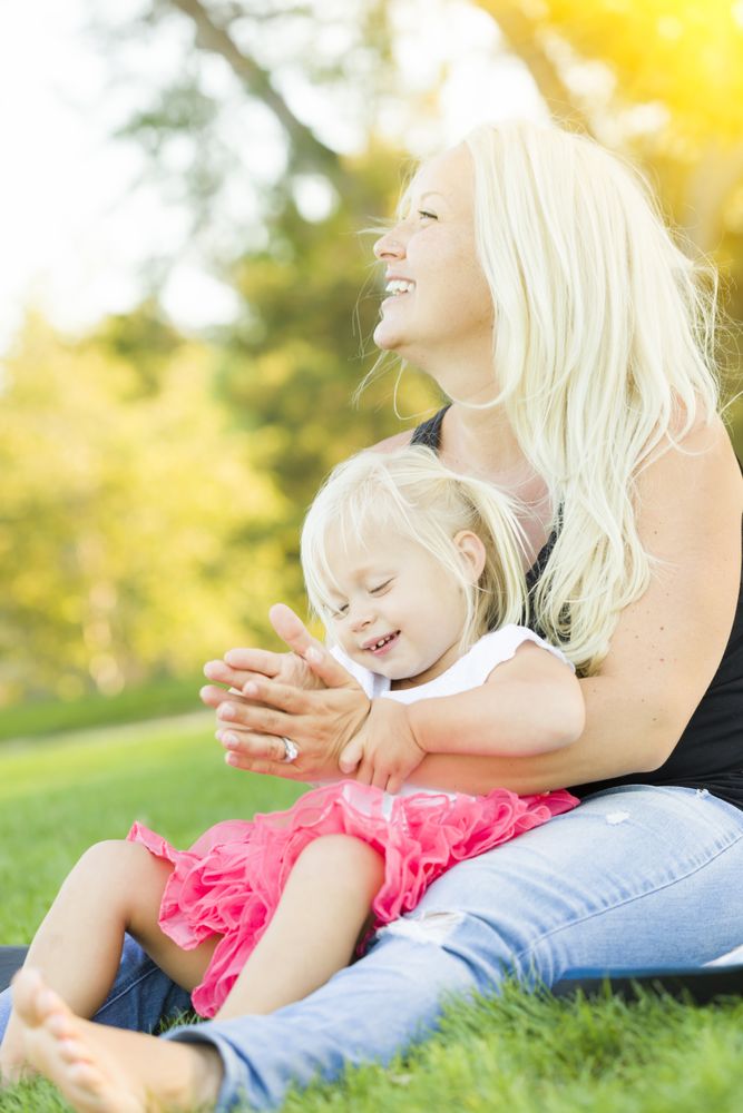 Mother and Little Girl Having Fun Together in Grass