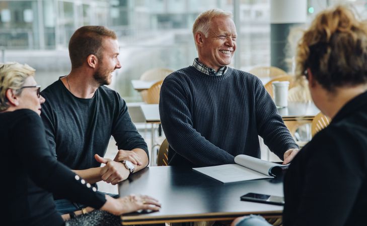 Smiling mature businessman having meeting with his team