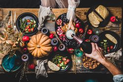 Autumnal table with squash and candles with man pouring a glass of champagne for a woman in lace