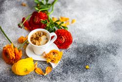 Summer floral card with espresso surrounded by fresh flowers with copy space