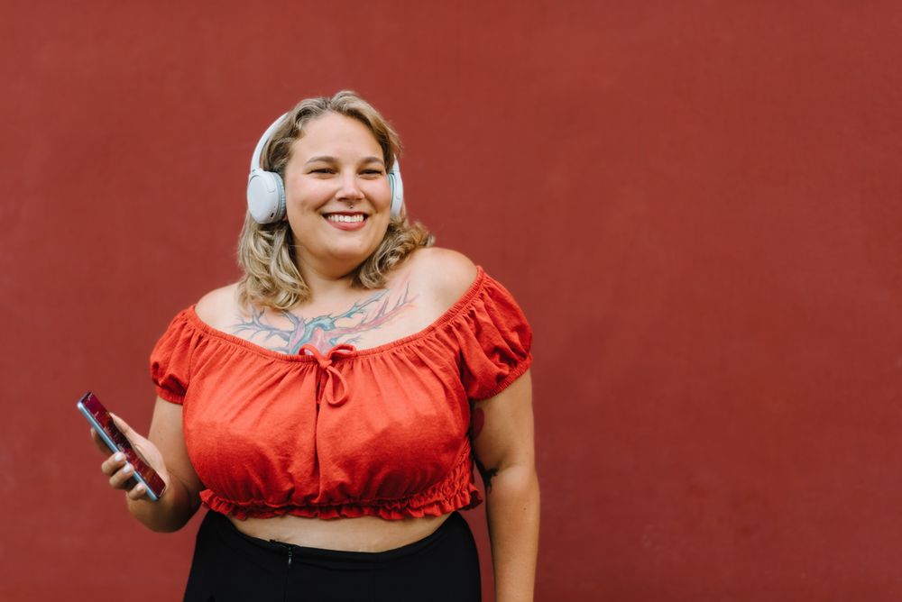 Cheerful woman with smartphone listening to music