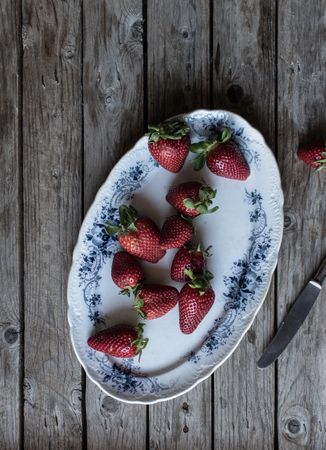 Plate with strawberries near napkin and knife