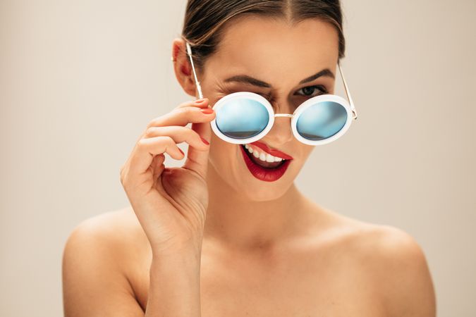 Portrait of beautiful young woman with sunglasses winking