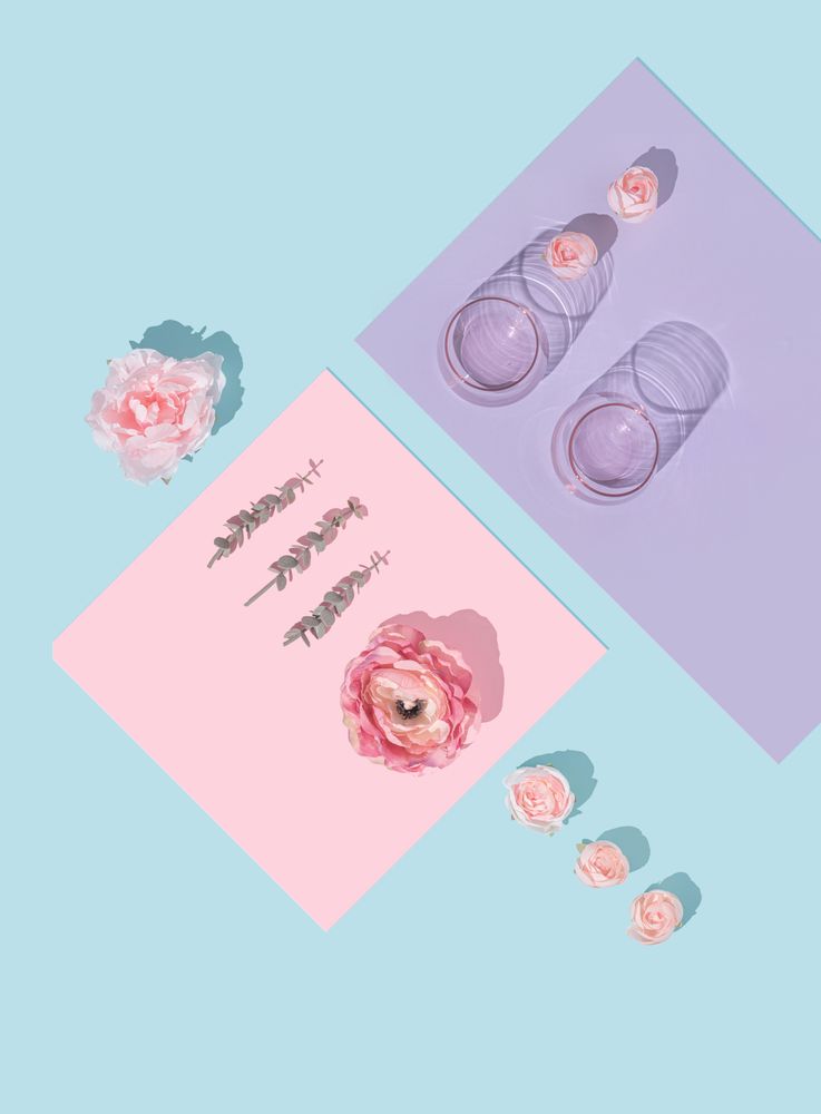 Top view of spring flowers and glassware on spring color background