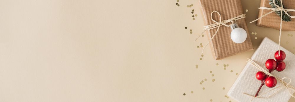 Paper brown Christmas presents on beige background with glitter