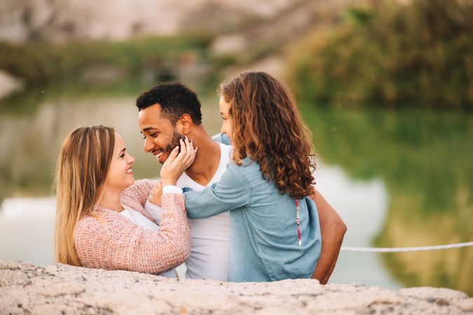 Cheerful multiethnic family cuddling on nature