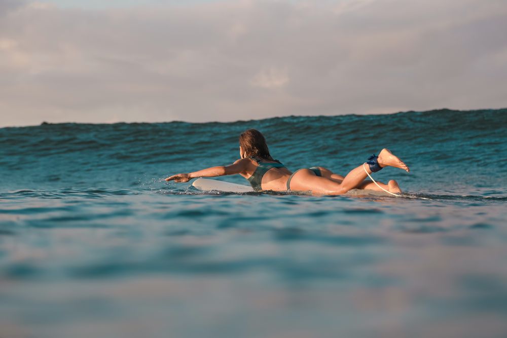 woman on surf board floating on water