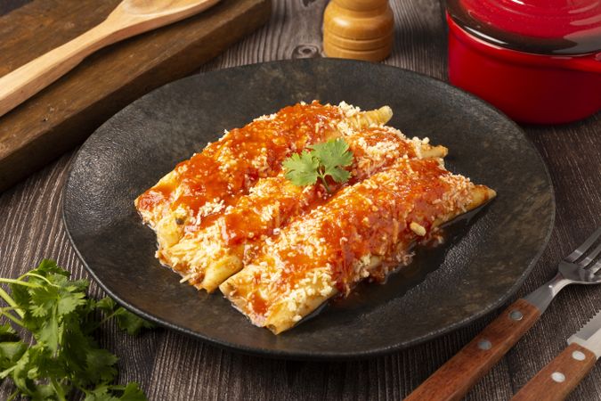 Pancakes stuffed with minced meat and topped with tomato sauce and grated cheese.