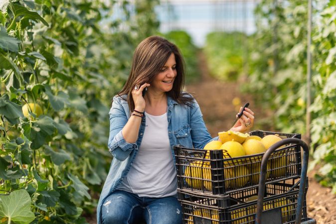 Farmer using smartphone while working in greenhouse