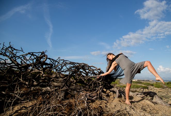 Woman posing on twigs of dry trees