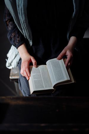 Cropped image of person reading bible in church