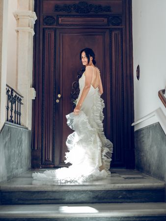 Gorgeous bride in wedding dress near wooden door