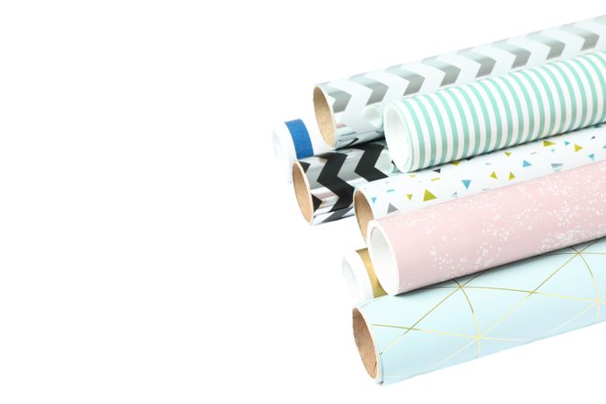 Rolls of festive wrapping paper on blank background. Space for text