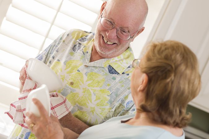 Adult Couple Washing Dishes Together Inside Kitchen