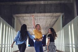 Cheerful friends walking through outdoor structure