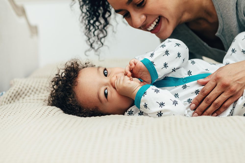 Baby boy lying down with smiling mother
