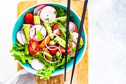 Top view of healthy chopped vegetables salad with chopsticks