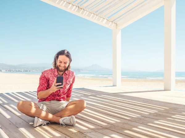 Man using smartphone on beach