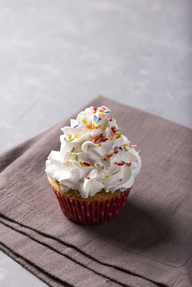 Tasty party cupcakes on the table. Cupcakes with whipped cream.