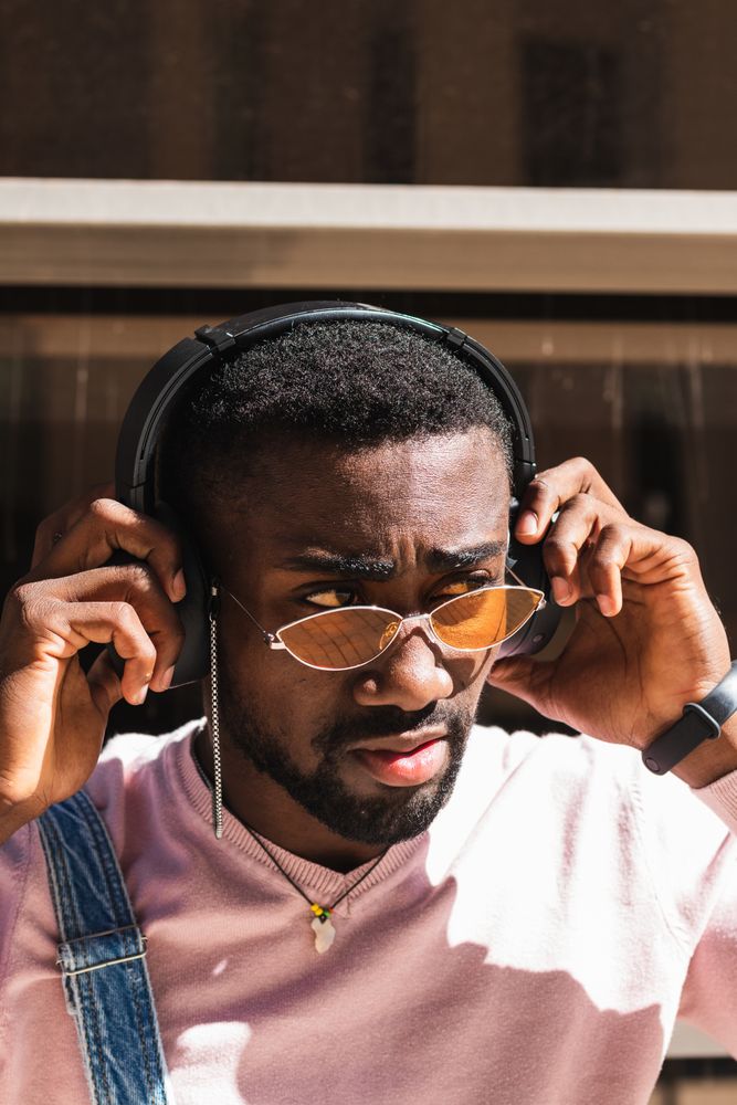 Stylish Black man listening to music in headphones