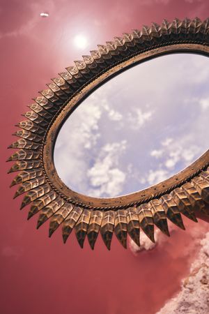 decorative mirror above pink lake water