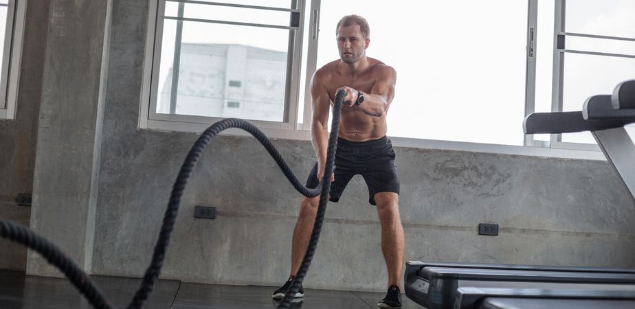 Man working out upper body with rope