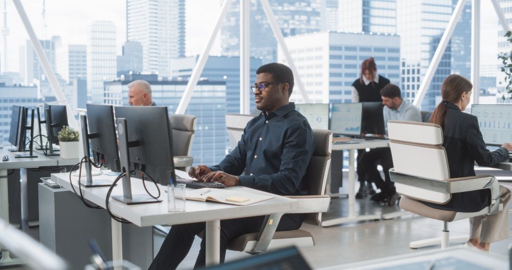 Professional Black Man Working In Consulting Company With Colleagues.