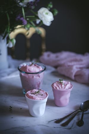 tasty glasses of strawberry mousse on a table with flowers