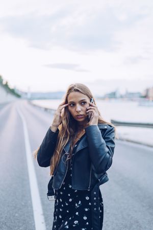 Long haired stylish woman speaking on smartphone