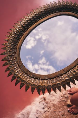 decorative mirror above pink lake water