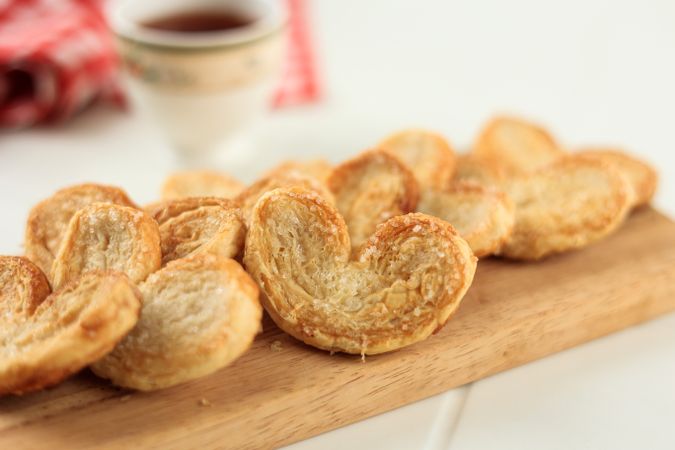 Tasty French Palmier Cookies Pastry and Tea on Wooden Table
